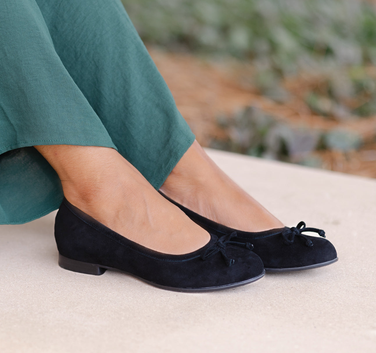 Joslynn kid suede in black flat with a dainty bow and half-inch wedge for comfort - lifestyle feet