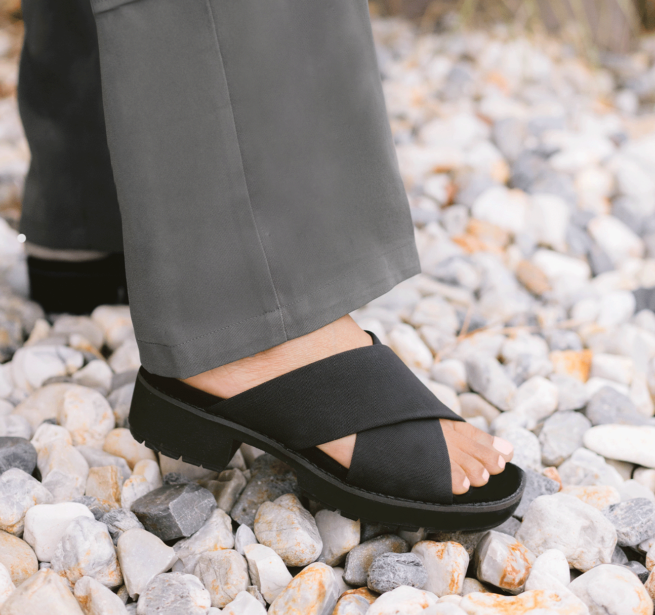 Dekkie slide sandal with wide black fabric bands crisscross the instep to support and comfort your feet-lifestyle